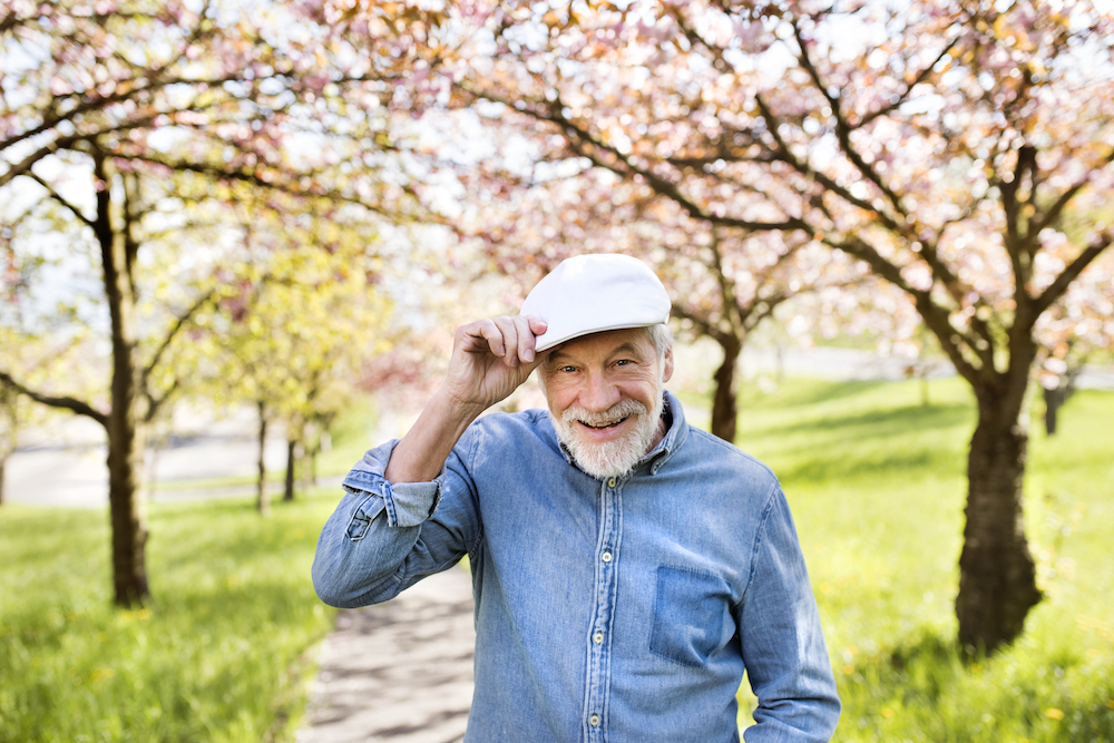 A senior man on a walk in nature near the memory care community in Vista